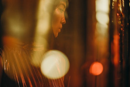 在一场喜庆的室内活动中，柔和的金色灯光照亮了一位女性的肖像，显得迷人而神秘