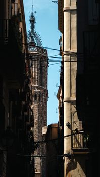 Explore the intricate Gothic architecture of Barcelona with its stunning stone tower framed by narrow alleys.