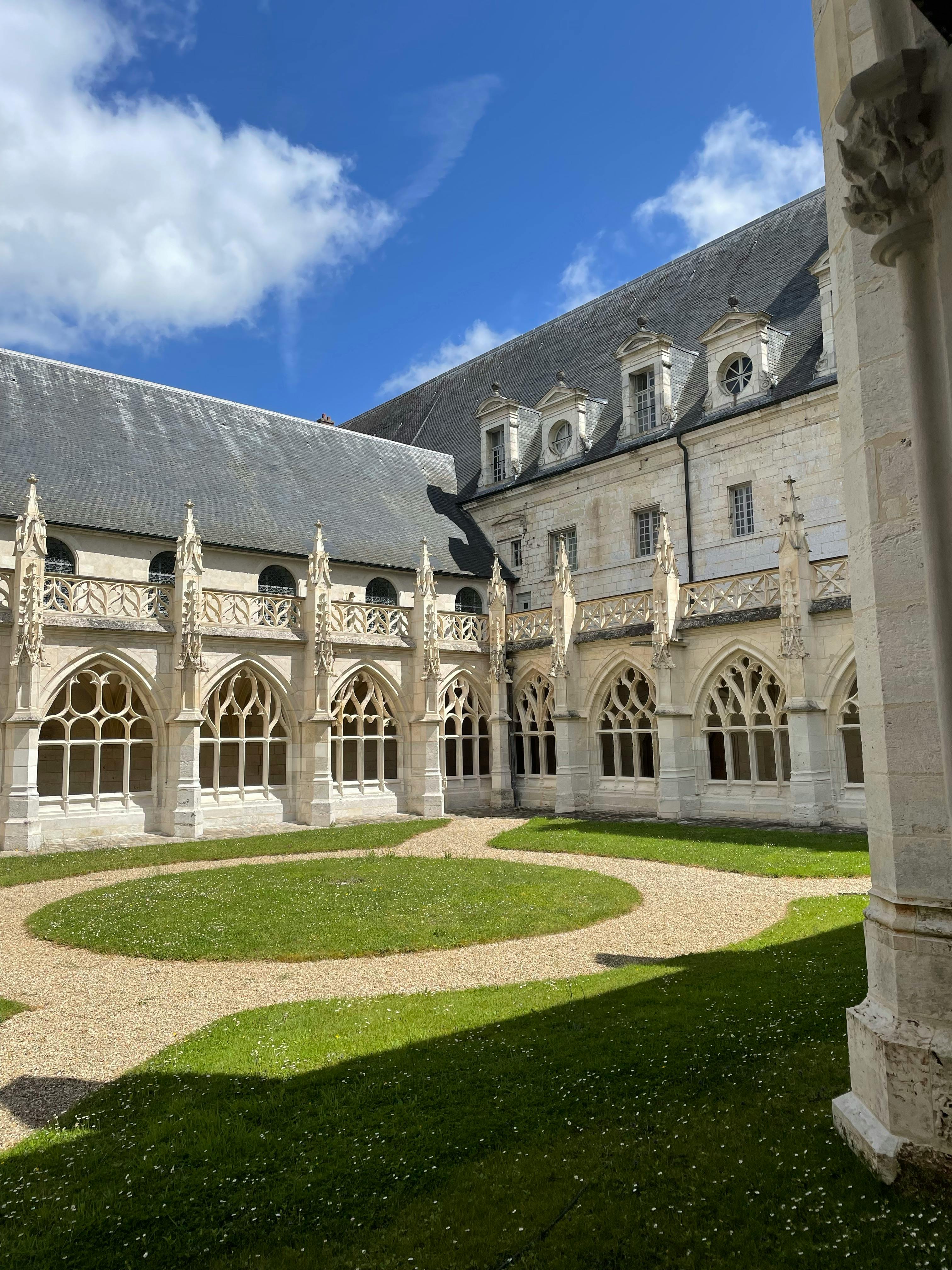Captivating Gothic courtyard with intricate arched windows under a clear blue sky.