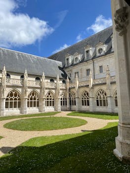 Captivating Gothic courtyard with intricate arched windows under a clear blue sky.