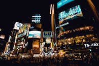 在东京涉谷十字路口，霓虹闪烁，人群熙攘，探索热闹的夜生活