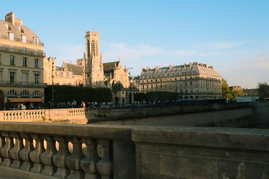 Beautiful architectural buildings illuminated by golden hour sunlight along the Seine River in Paris, France.