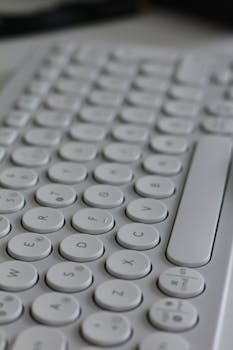 An artistic close-up of a sleek white round key keyboard, highlighting design.