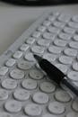 Close-Up of White Keyboard with Pen for Office Use