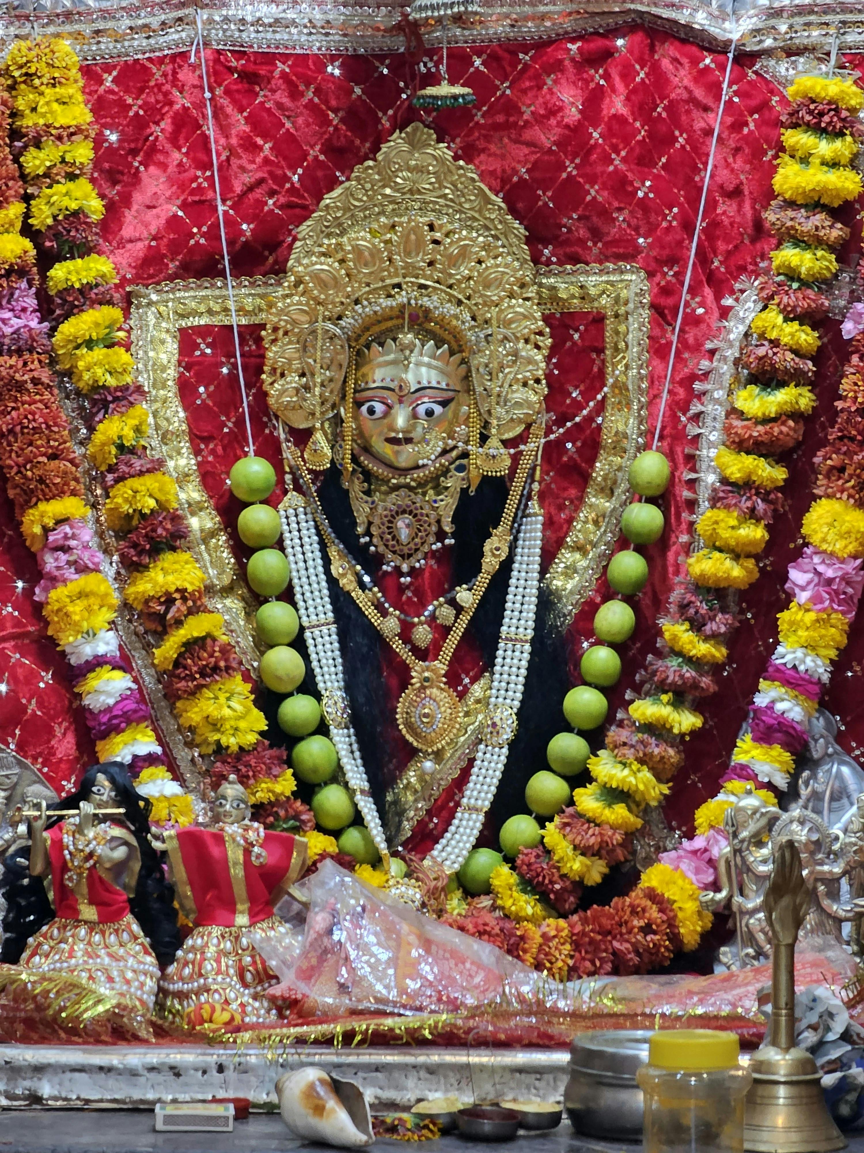 Intricate Durga Puja altar with deity idol adorned with vibrant flowers