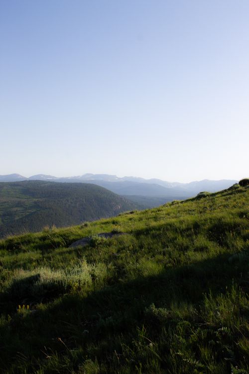 Free Peaceful mountain landscape during golden hour showcasing lush green hills under a clear sky. Stock Photo