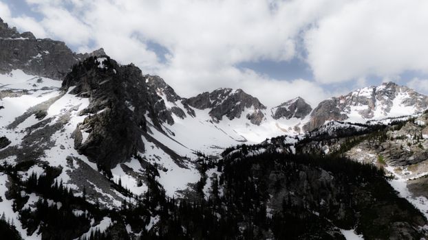 Majestic snow-capped mountains with dramatic clouds, capturing nature's beauty and tranquility.