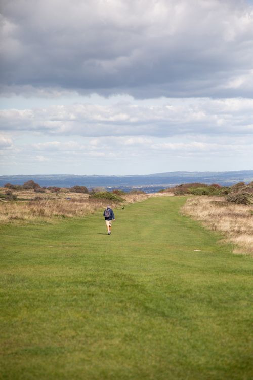 Free A lone walker traverses a scenic countryside path under cloudy skies in England. Stock Photo