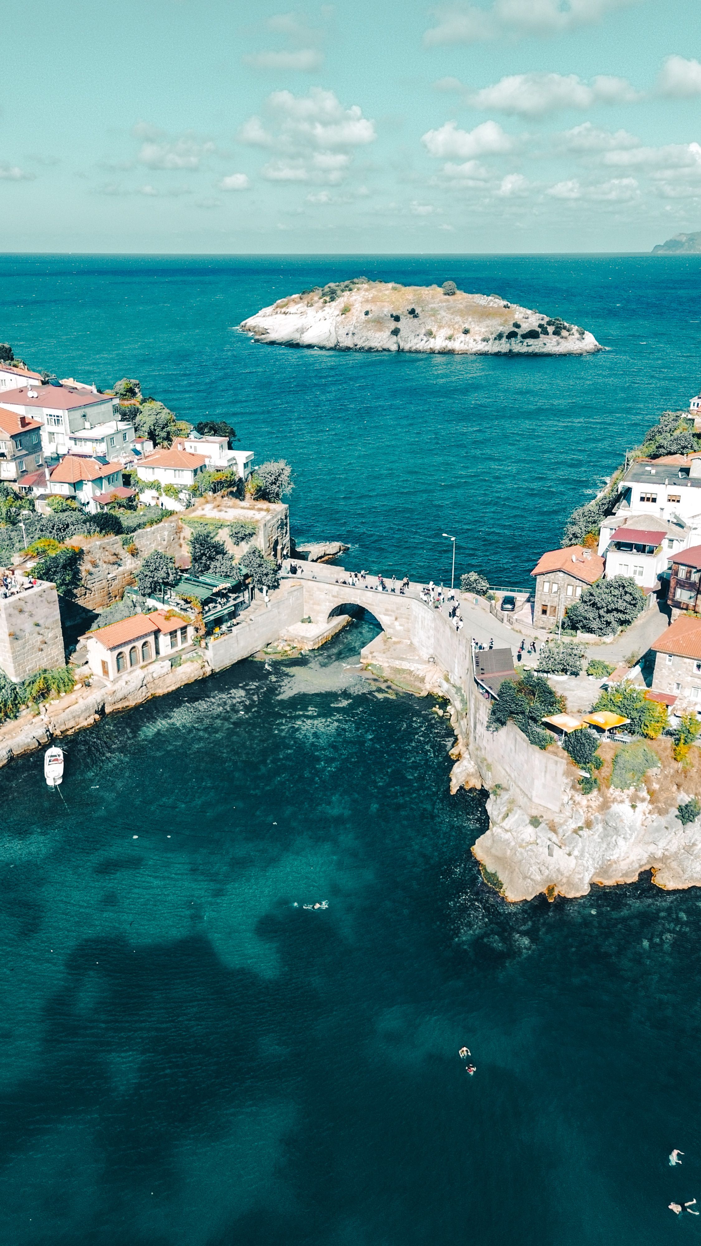 Breathtaking aerial view of Amasra's ancient bridge and turquoise coastline against the Black Sea.