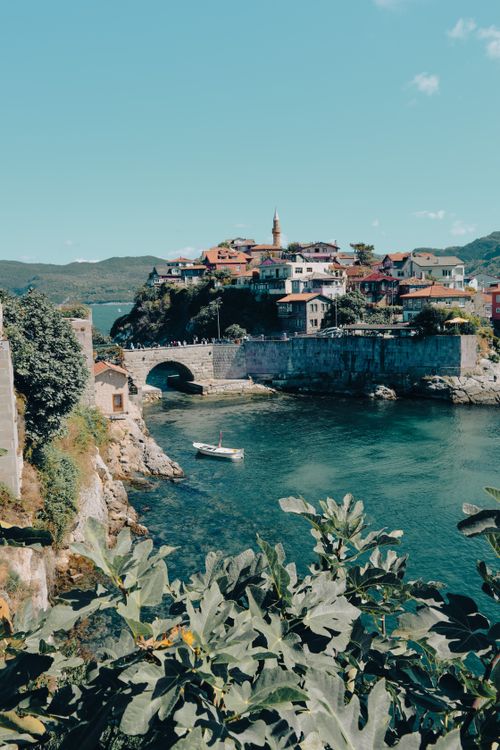 Free Picturesque view of Amasra with its ancient bridge, clear sea, and colorful houses under a bright sky. Stock Photo