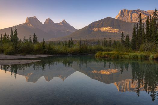 Breathtaking sunrise reflection of Three Sisters mountains at Canmore, Alberta, Canada.