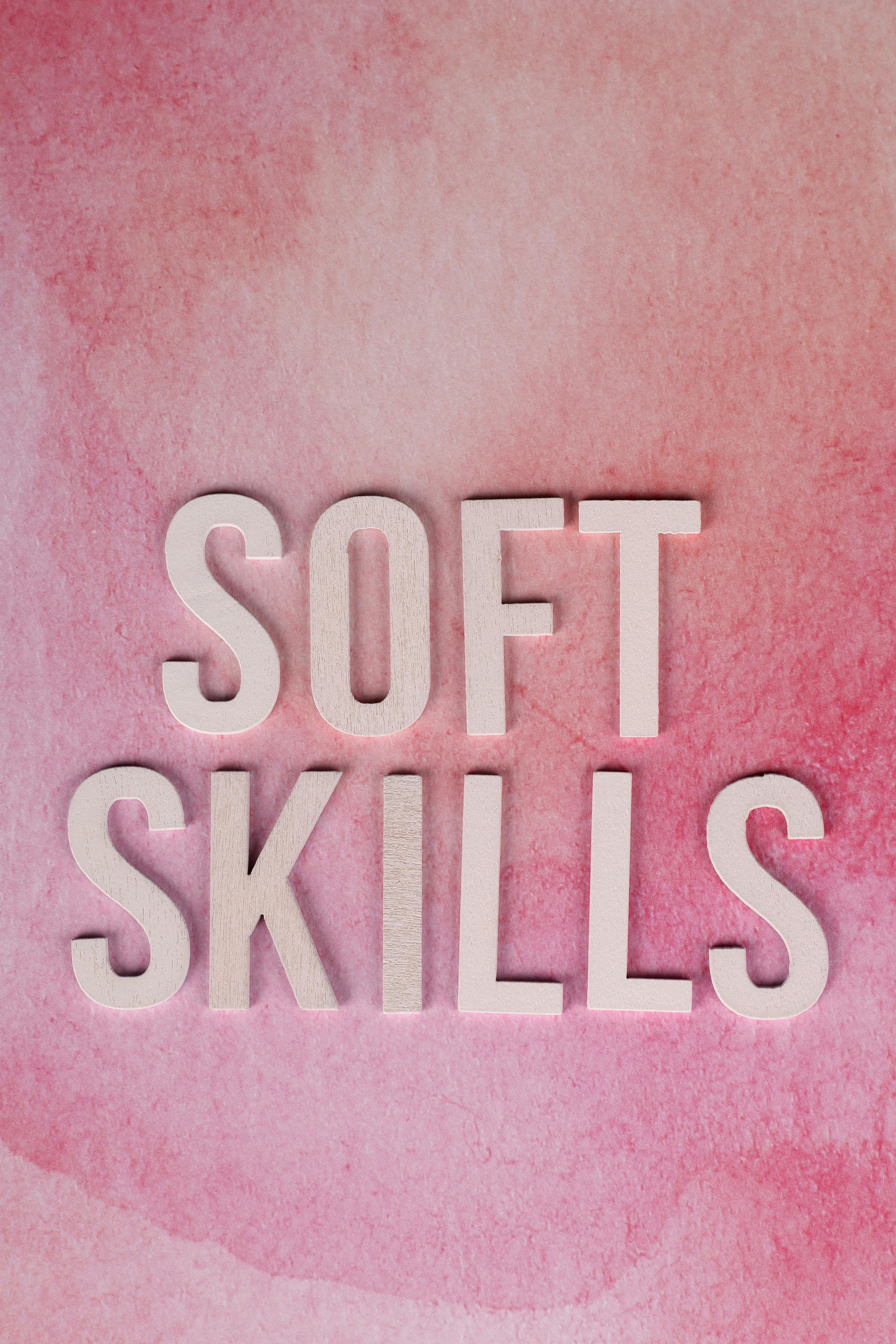 Conceptual image of soft skills typography on a pink watercolor background.