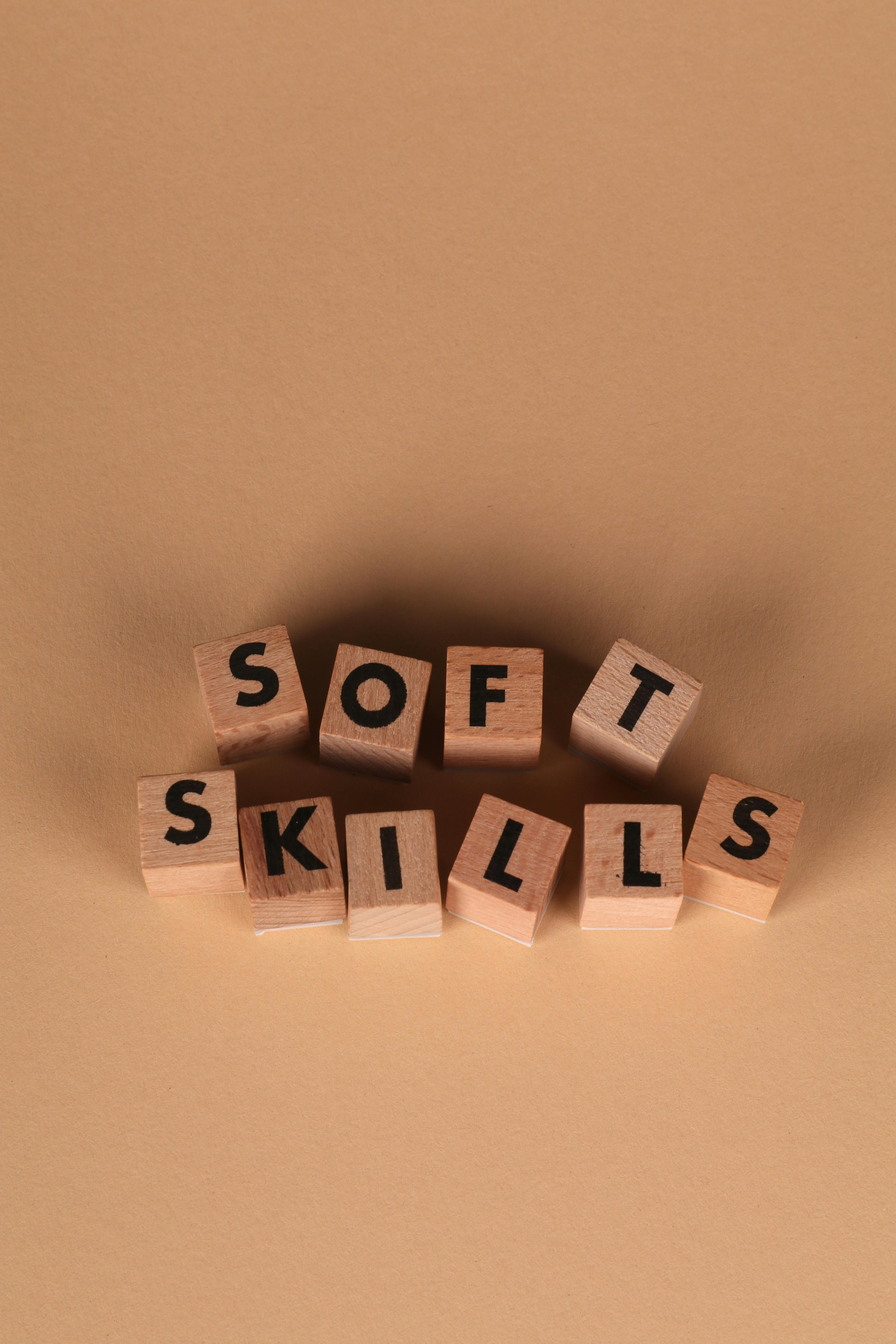 Wooden blocks arranged to spell 'Soft Skills' on a brown background