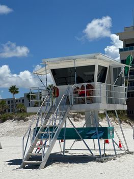 Lifeguard station on a bright day at the beach with clear blue skies and white sand.