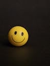 Minimalist Smiley Face Ball on Dark Background