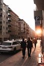 日落时分，人们沿着城市街道的人行道行走