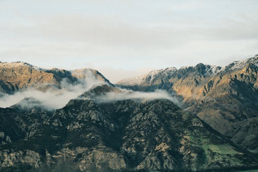 Breathtaking view of snow-capped mountains with clouds in New Zealand.
