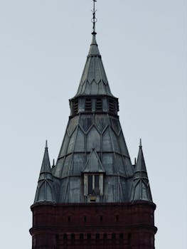 Close-up of a historic Gothic-style tower against a clear sky.