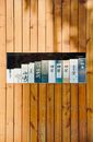 Wooden wall with a variety of sake boxes, showcasing traditional Japanese beverage packaging.