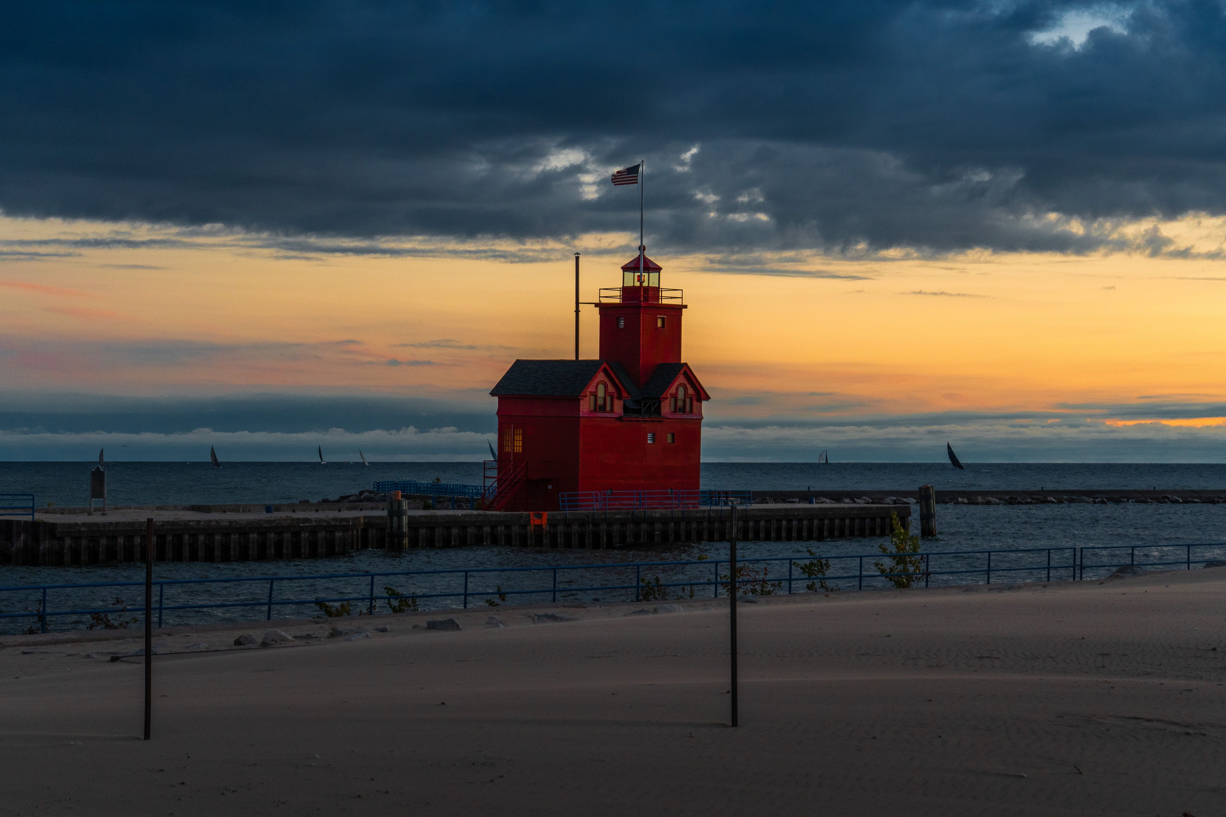 Holland Harbor Lighthouse glowing at sunset on Lake Michigan