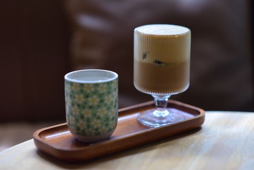 Free Cup of hot tea and glass of iced coffee on wooden tray on table. Stock Photo