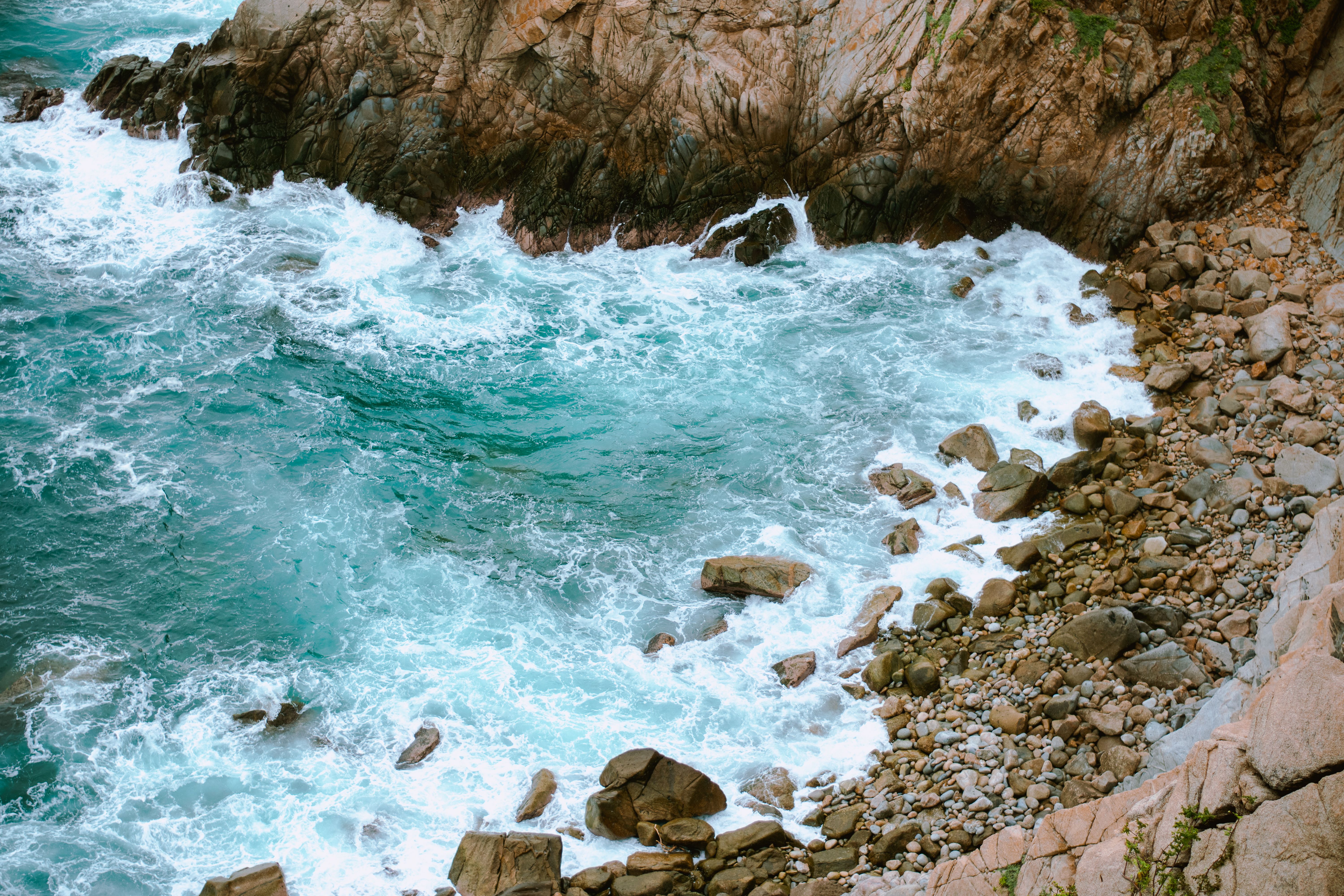 Aerial view of waves crashing on the rocky coastline near where to stay in Huatulco, Oaxaca