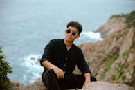 Man Relaxing on Cliff Overlooking Ocean
