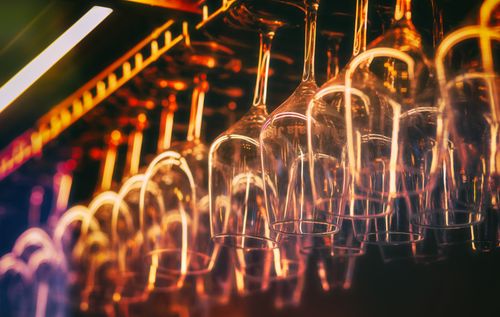 Free Close-up of hanging wine glasses in warm ambient lighting at a bar in El Puerto, País Vasco. Stock Photo