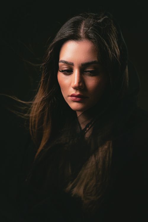 Free A moody portrait of a young woman with flowing hair, captured in soft, intimate lighting. Stock Photo