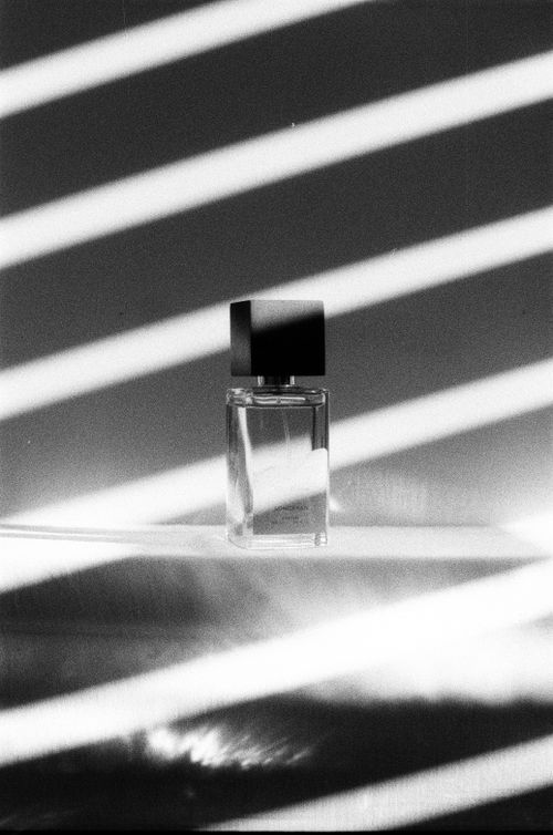 Free Monochrome photo of a perfume bottle with striped shadows. Stock Photo