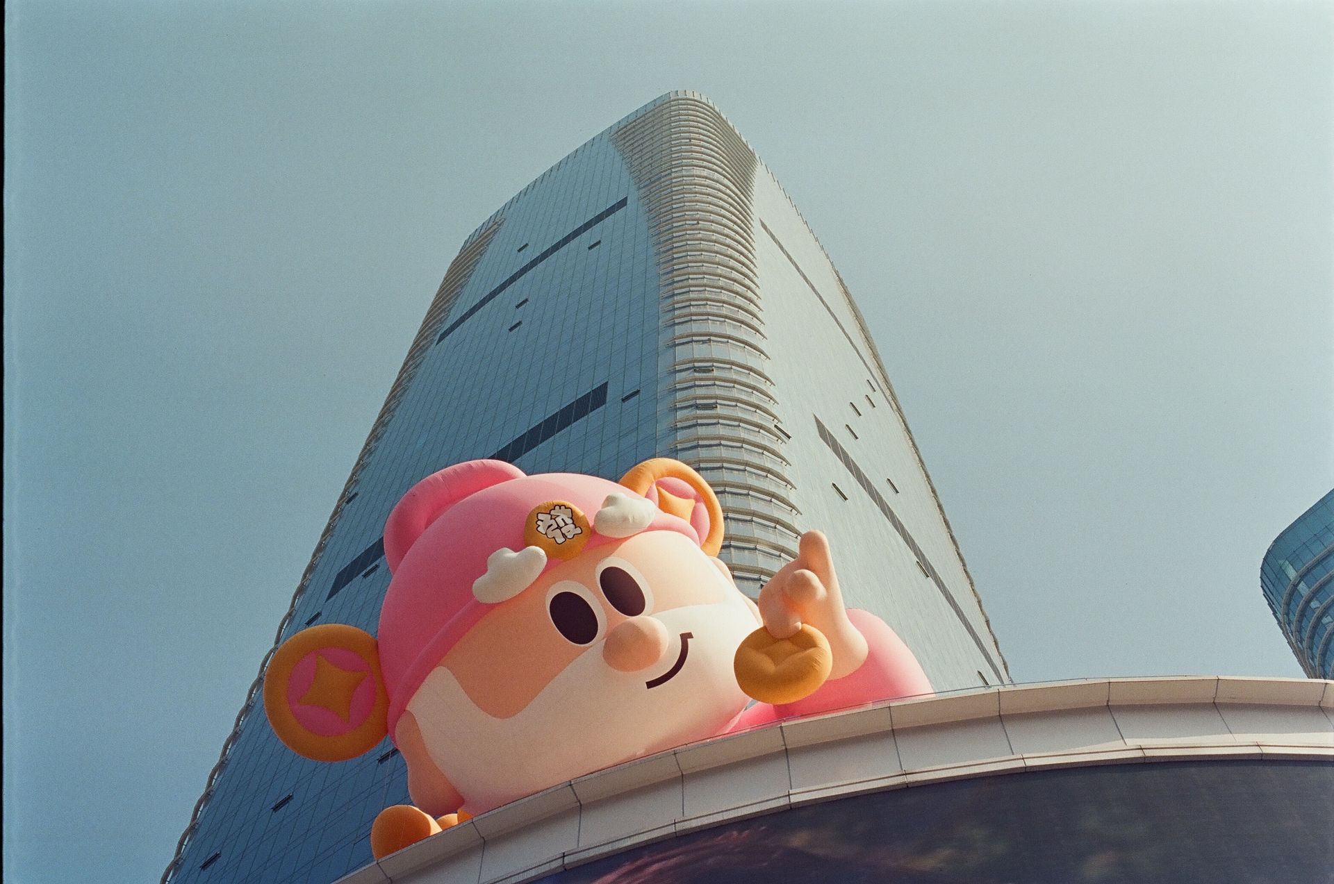 Giant cartoon balloon with a skyscraper backdrop, vibrant and playful.