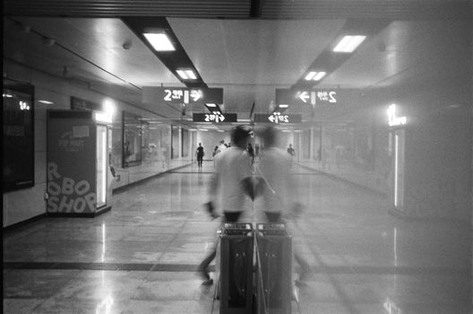 Long exposure in a subway station with blurred figures passing through.