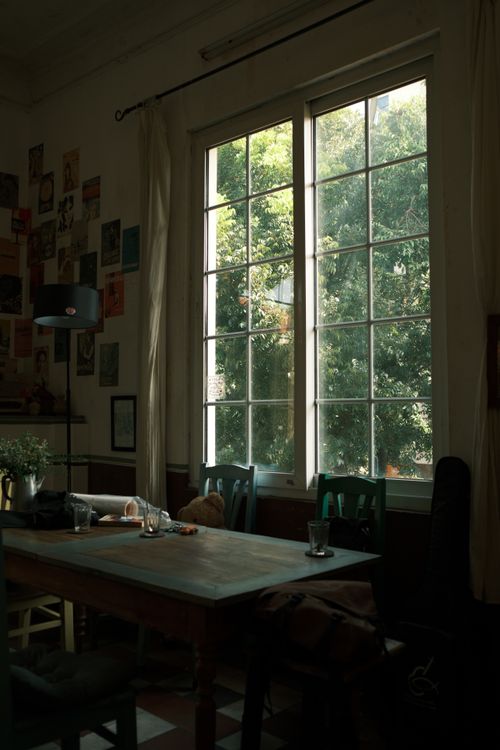 Free Sunlit cozy dining room with large windows and decorative wall art in Jamaica. Stock Photo