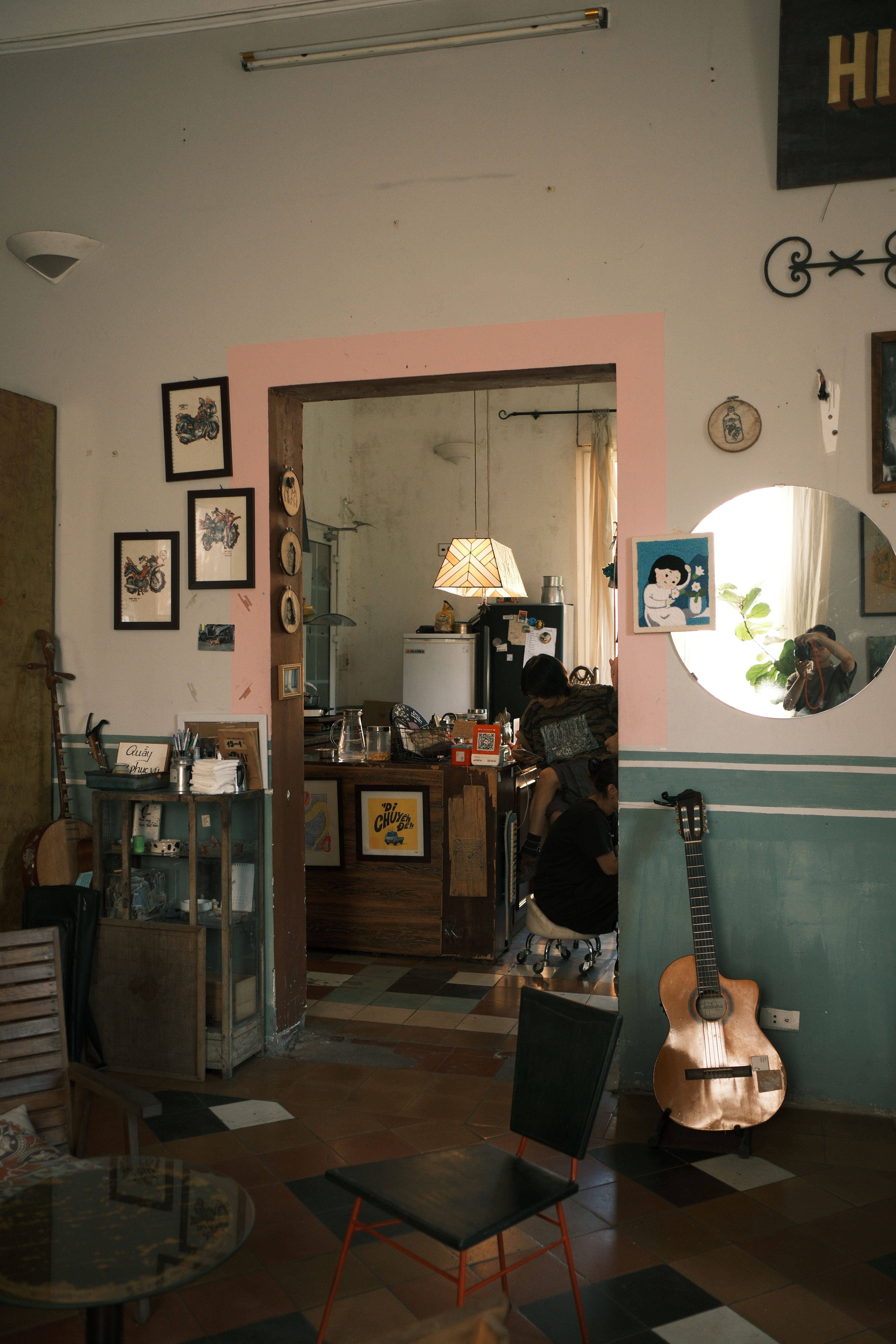 Warm interior of a Jamaican café with vintage decor and a classical guitar leaning against the wall.