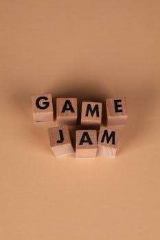 Top view of wooden blocks spelling 'Game Jam' on a brown background, representing a creative event.