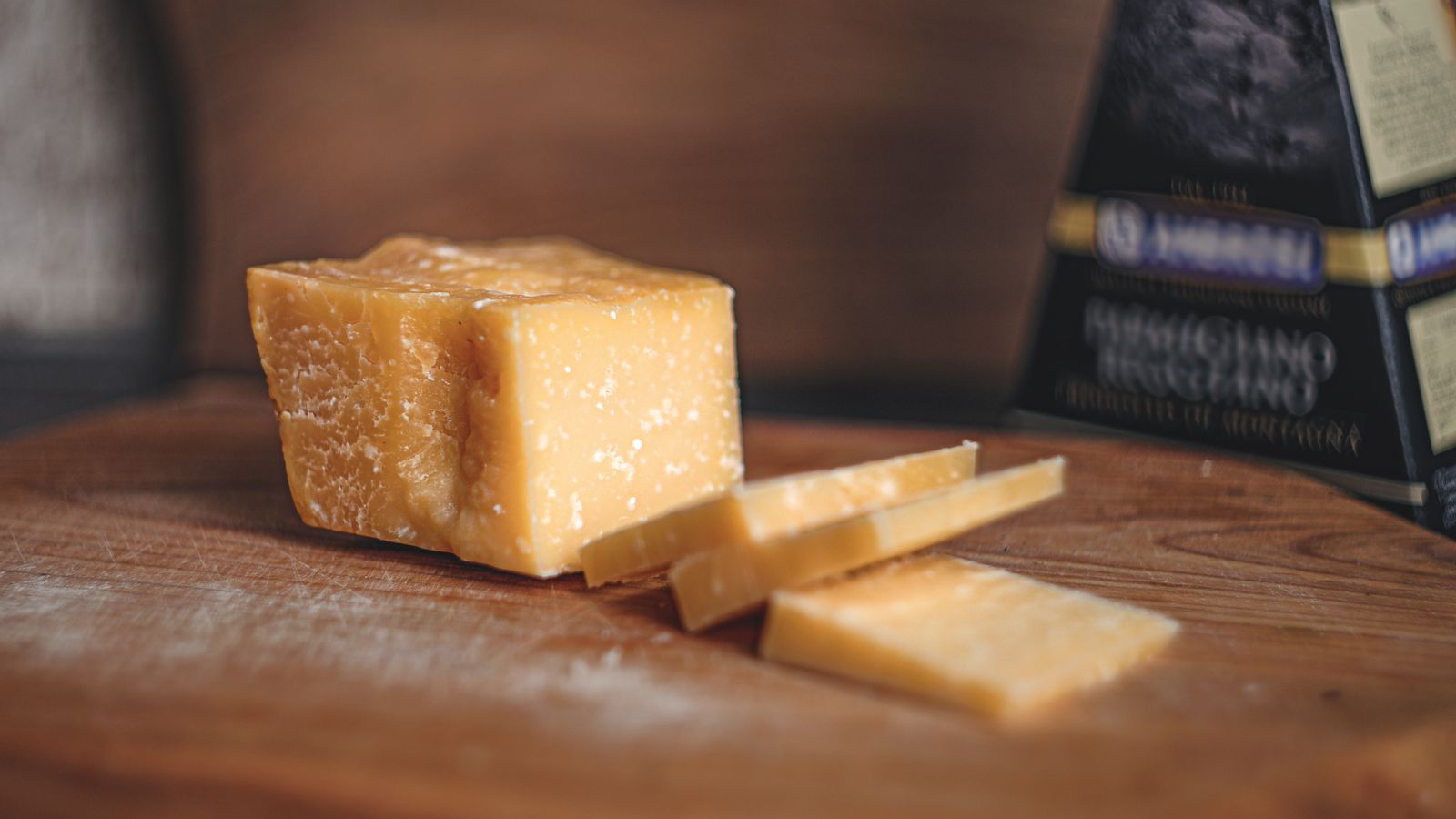 Close-up of Parmigiano Reggiano cheese on a wooden board — photo by Ahimsa - OM on Pexels Close-up of Parmigiano Reggiano cheese on a wooden board