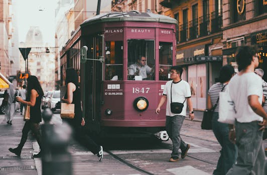 Un classico tram di Milano circondato dai pedoni durante il giorno, a testimonianza della vita urbana.