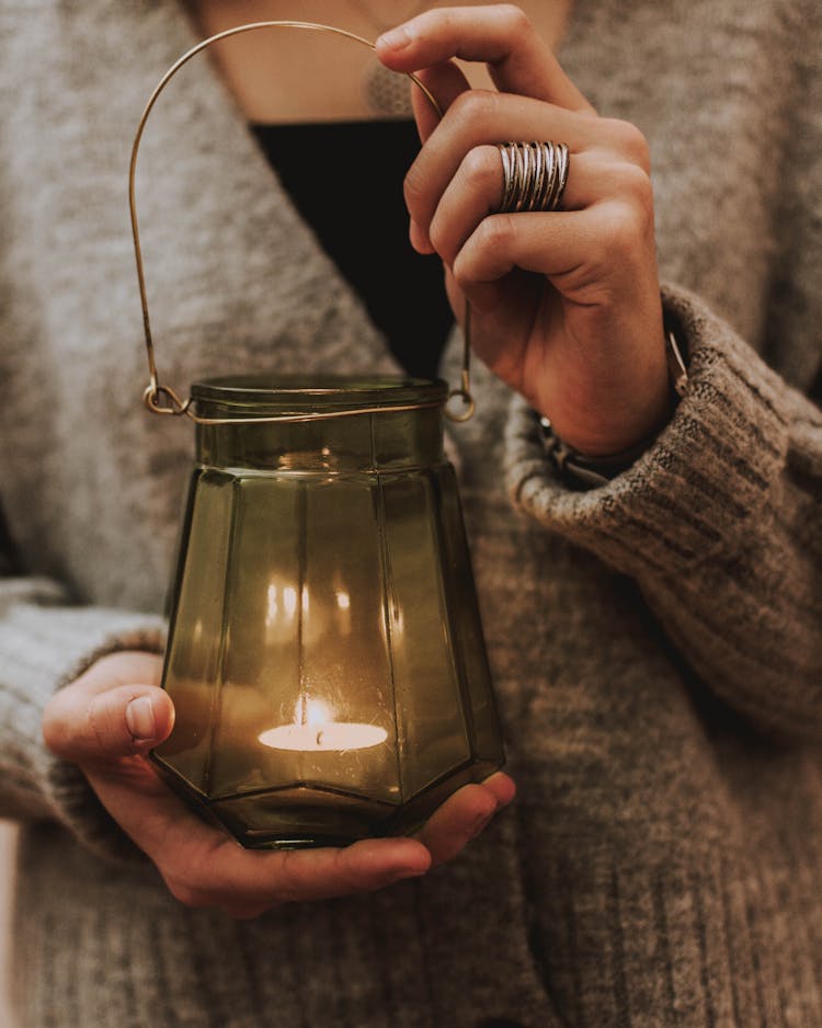 Photo Of Person's Hands Holding Candle Lamp