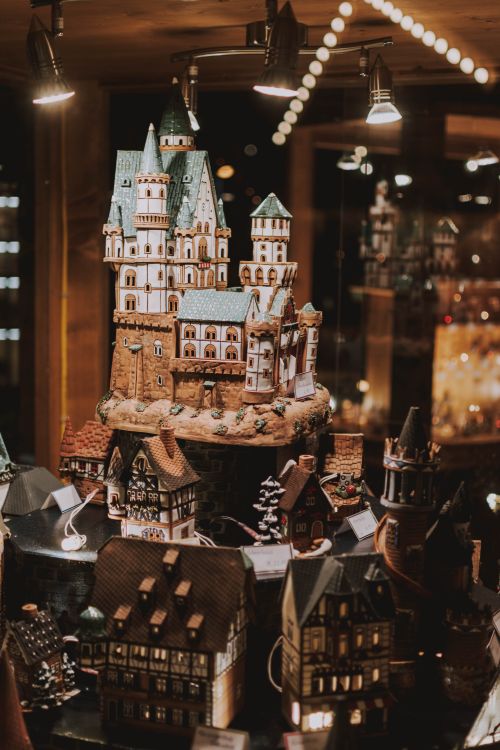 Free Through glass of amazing handicraft souvenirs in shape of castles and houses placed on showcase of traditional shop Stock Photo