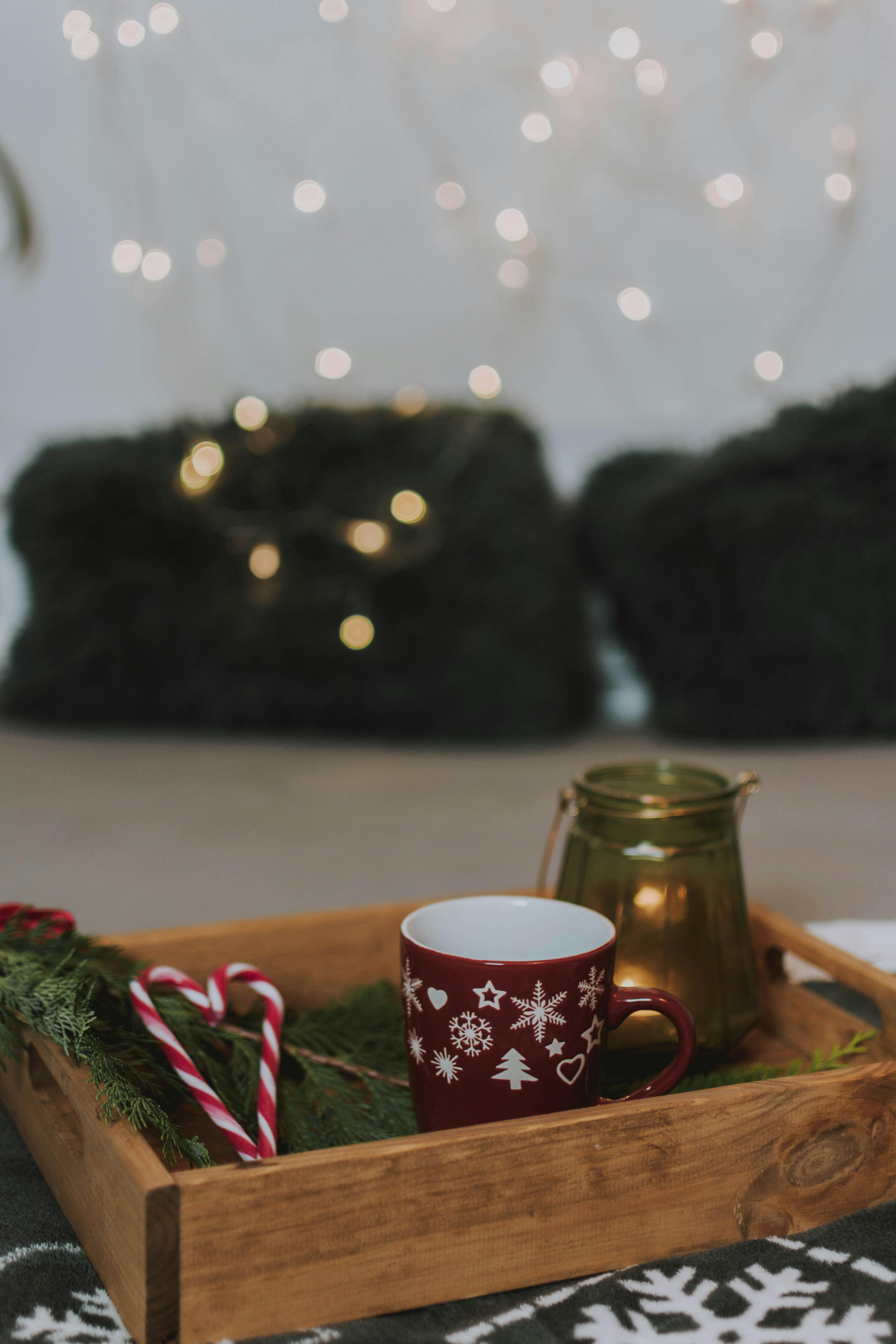 shallow focus photo of maroon and white christmas themed ceramic mug