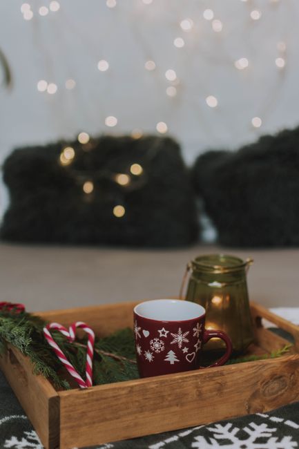 Warm and inviting Christmas scene with hot drink, candy canes, and festive lights.