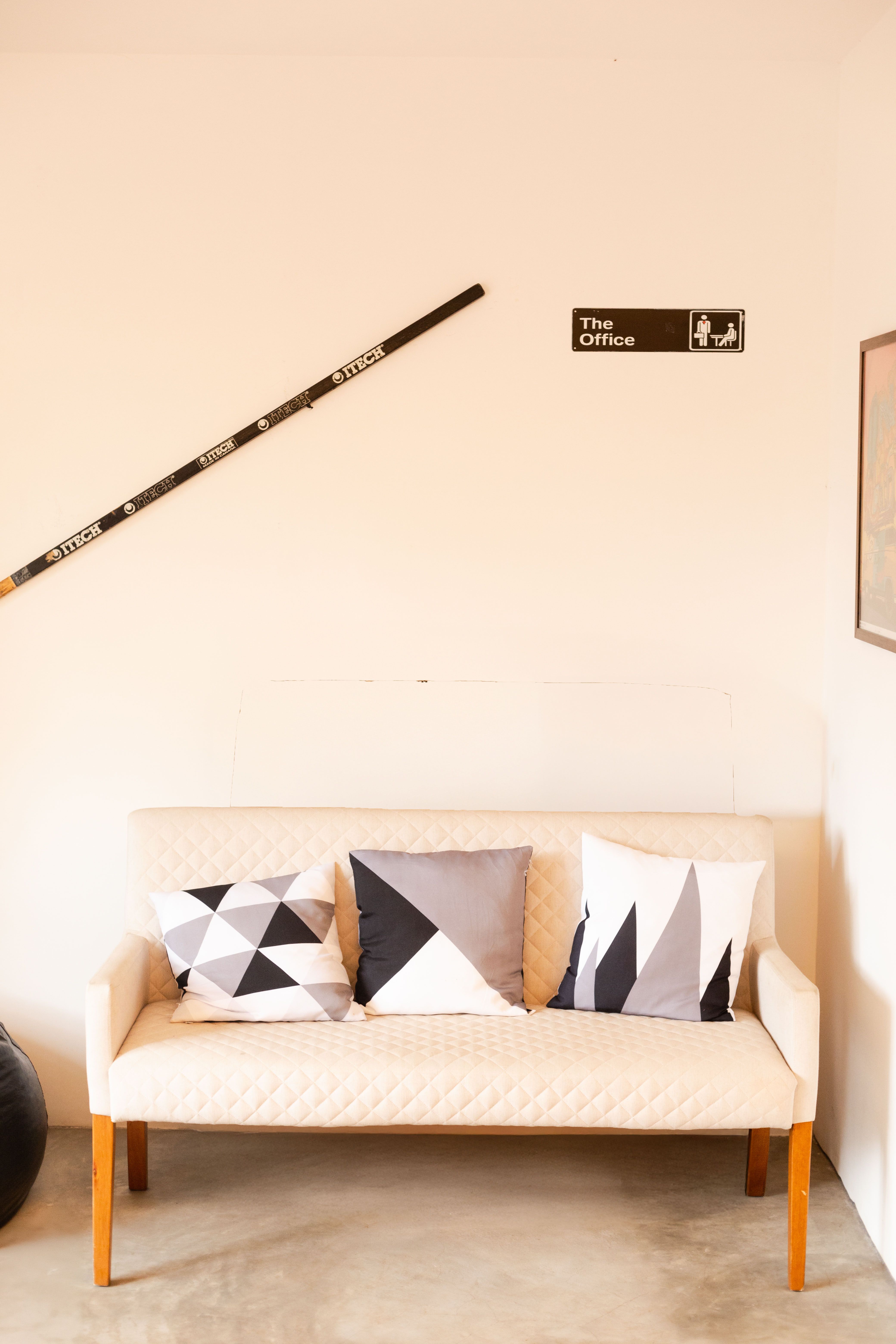 Modern office corner with a minimalistic sofa and geometric pillows in São Paulo.
