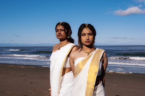 Free Two women in traditional sarees stand gracefully on a sunny Vancouver beach, showcasing cultural elegance. Stock Photo