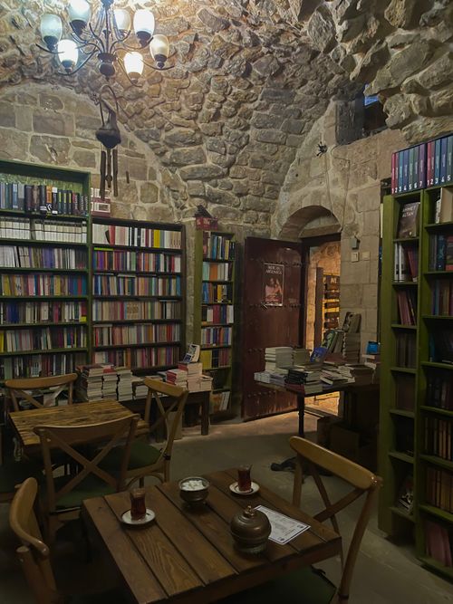 Free Charming stone-walled bookstore featuring wooden furniture and warm lighting. Stock Photo