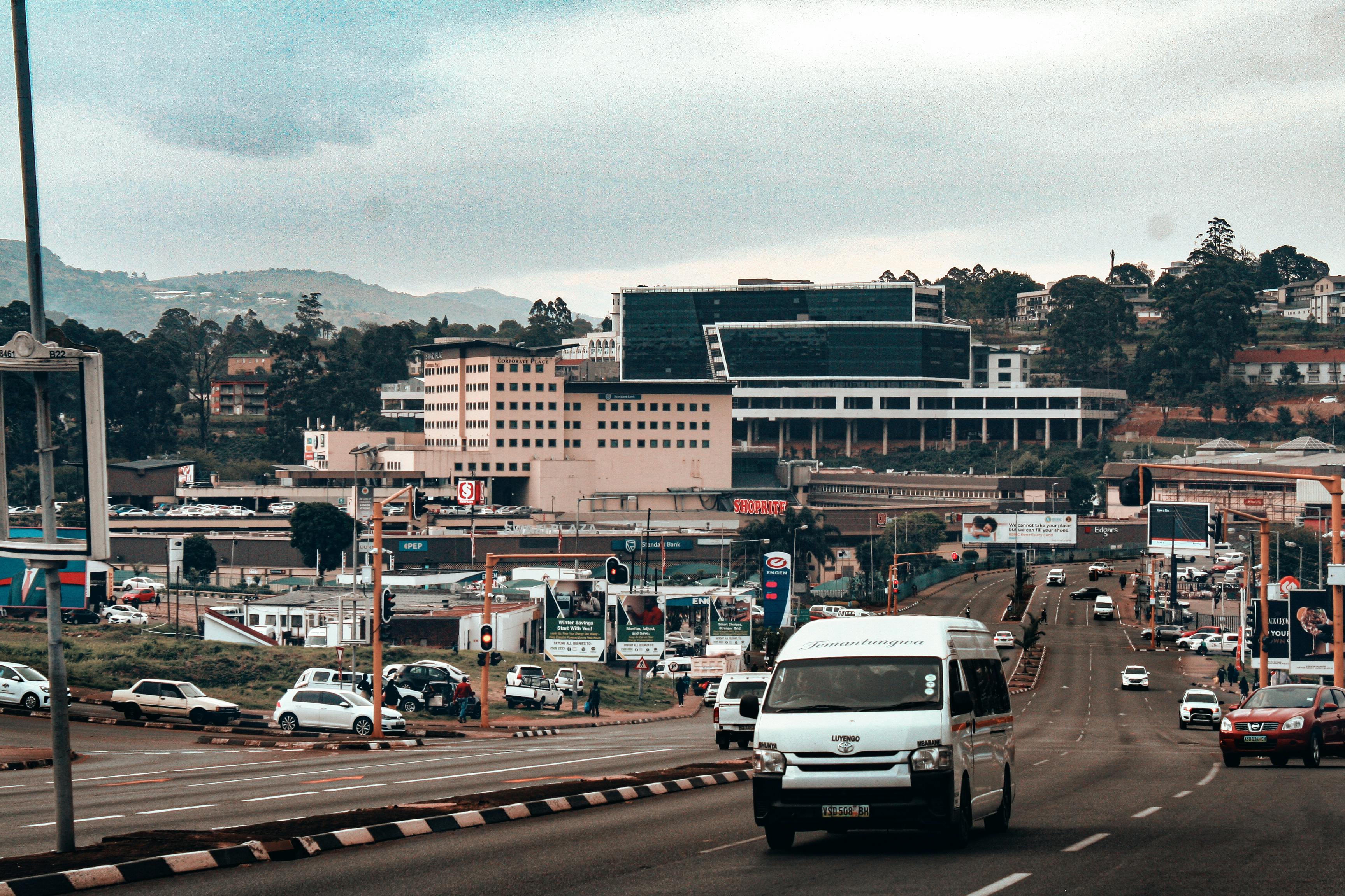 A vibrant urban street in Mbabane, Eswatini with vehicles and buildings, showcasing city life.
