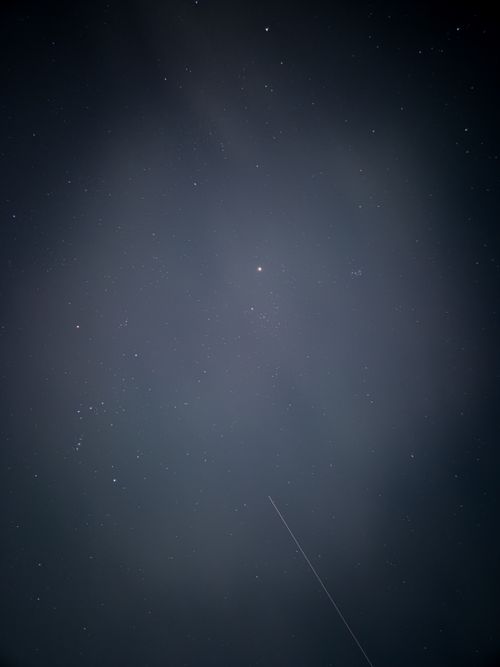 Free A serene night sky filled with stars and a visible shooting star crossing the scene. Stock Photo