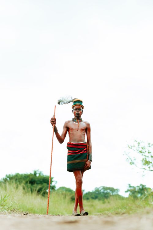 Free A Karamoja warrior in traditional attire with spear in Nakapiripirit, Uganda. Stock Photo