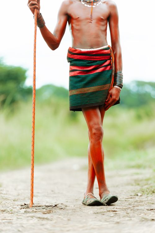 Free Colorful traditional attire showcased on a dirt path in Nakapiripirit, Uganda. Stock Photo