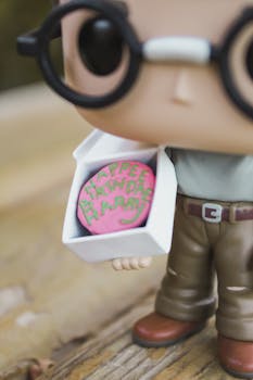 Vinyl figure holding a box with pink 'Happy Birthday Harry' cake.
