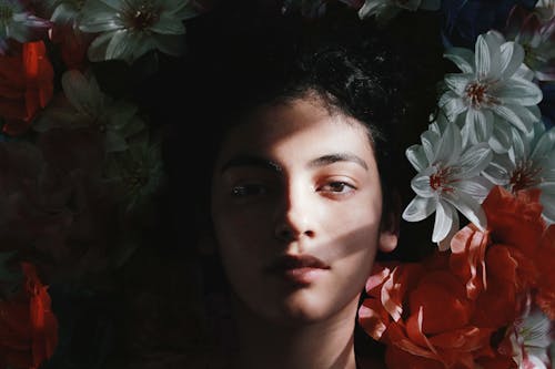 çiçekler üzerinde Yatan Kadının Seçici Odak Fotoğrafı
